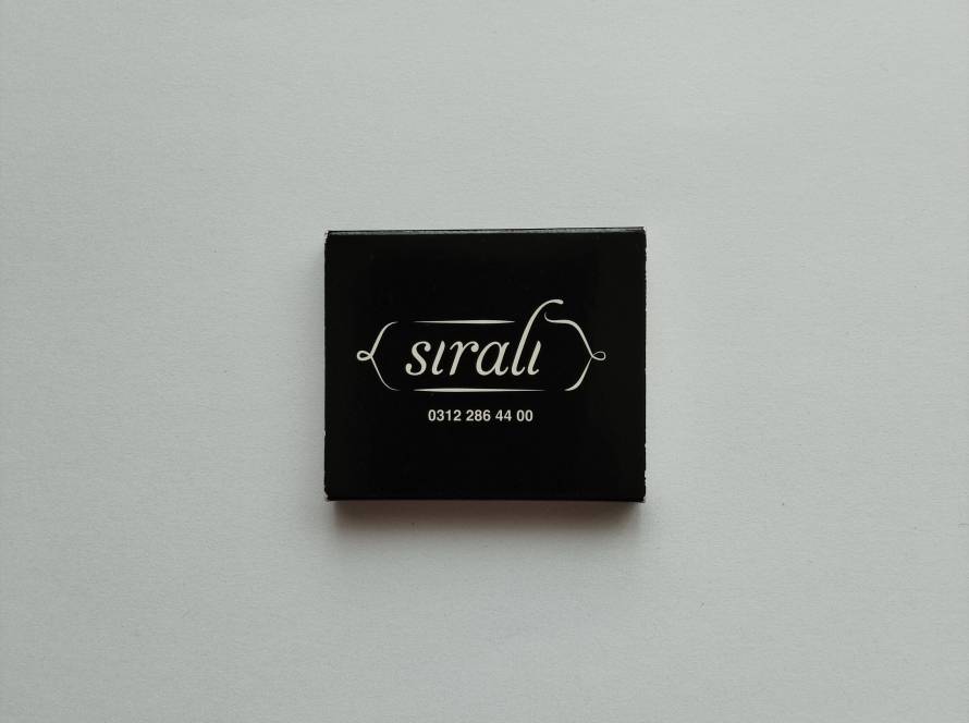 Sıralı restaurant script logo with phone number on black background