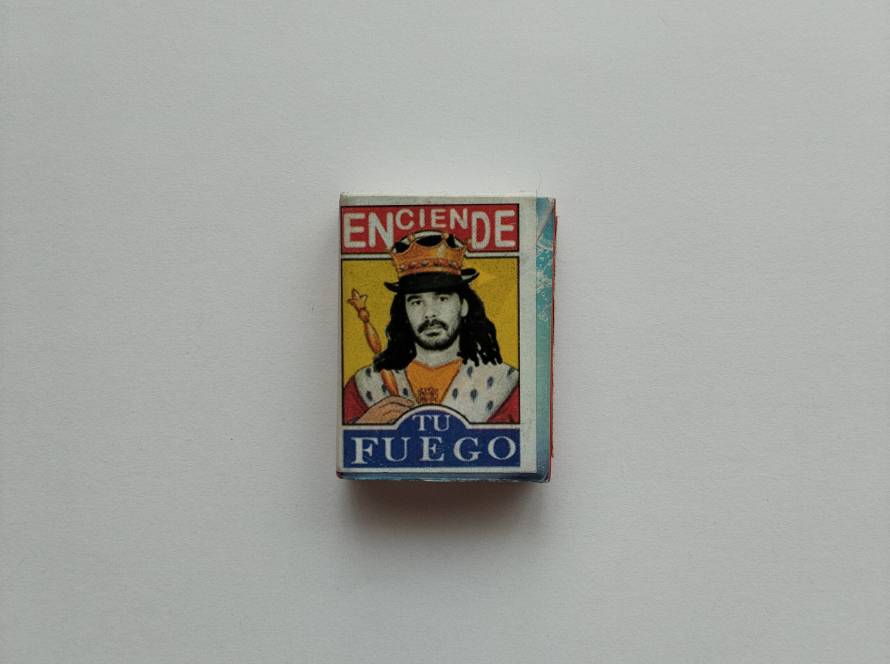 Colorful illustrated matchbox featuring crowned figure and Spanish slogan “Enciende Tu Fuego”