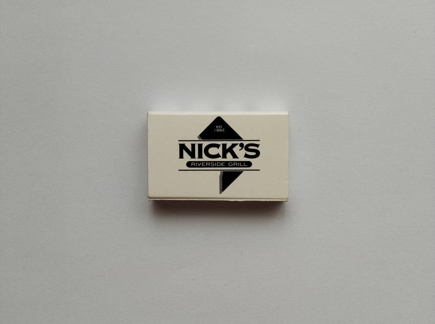 Nick’s Riverside Grill logo with geometric black emblem