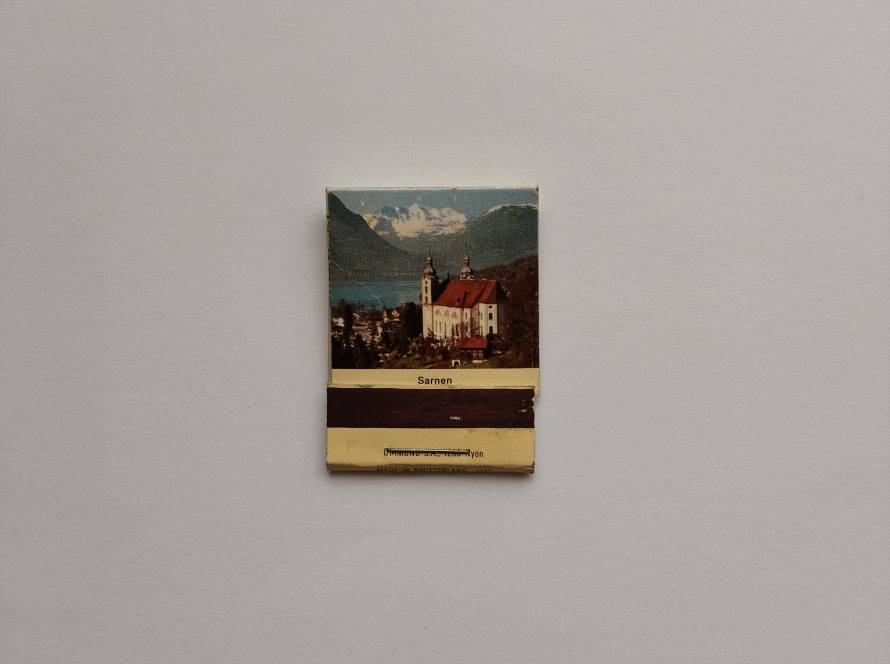 Scenic Sarnen village with church and alpine lake, Swiss souvenir matchbox