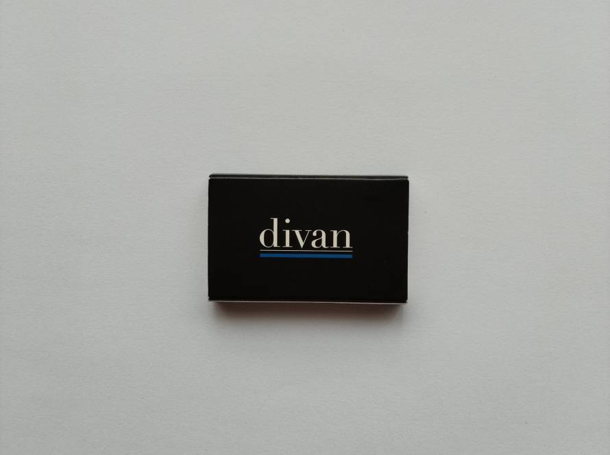 “Divan” branded minimalist black matchbox with white typography and blue underline