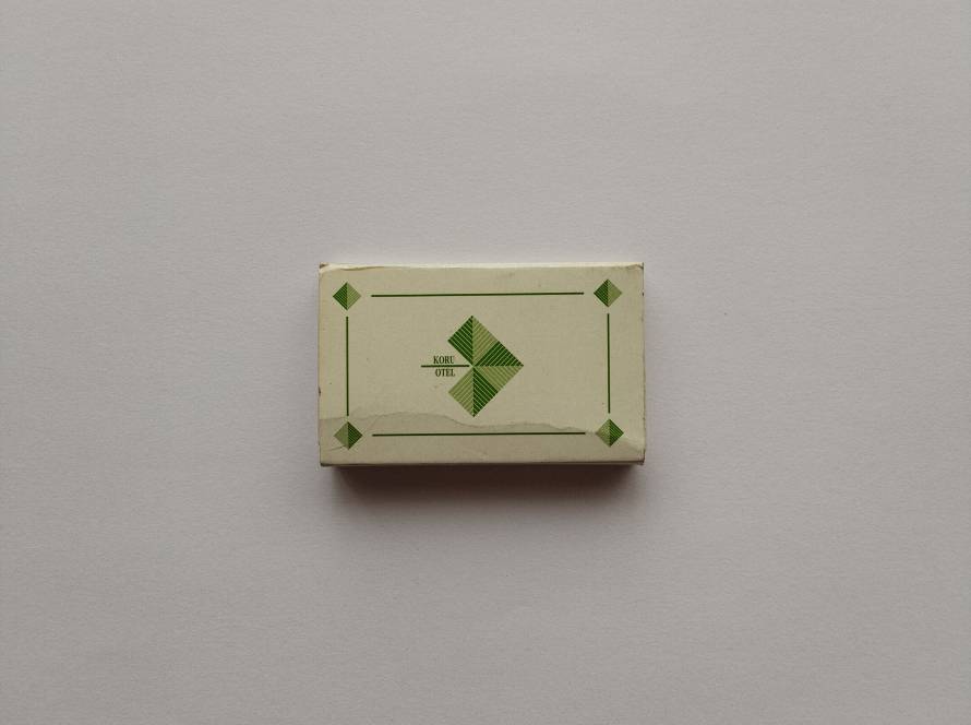 Minimalist vintage matchbox with green geometric border and diamond motif