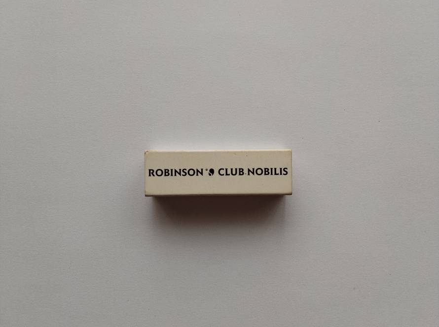 Minimalist promotional matchbox for Robinson Club Nobilis, featuring clean black typography on cream background