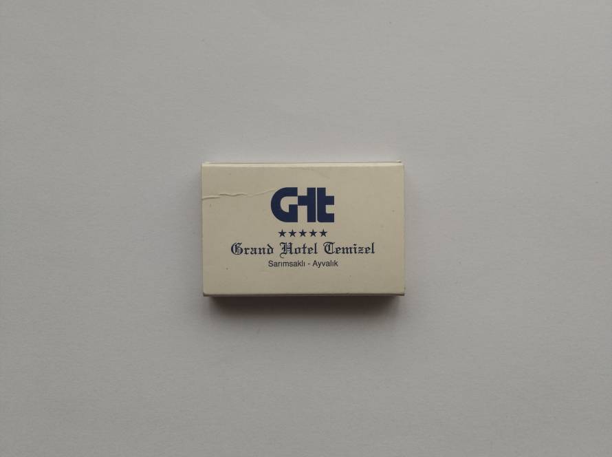 “Grand Hotel Temizel – Sarımsaklı Ayvalık” promotional hotel matchbox with blue GHT logo and star rating.