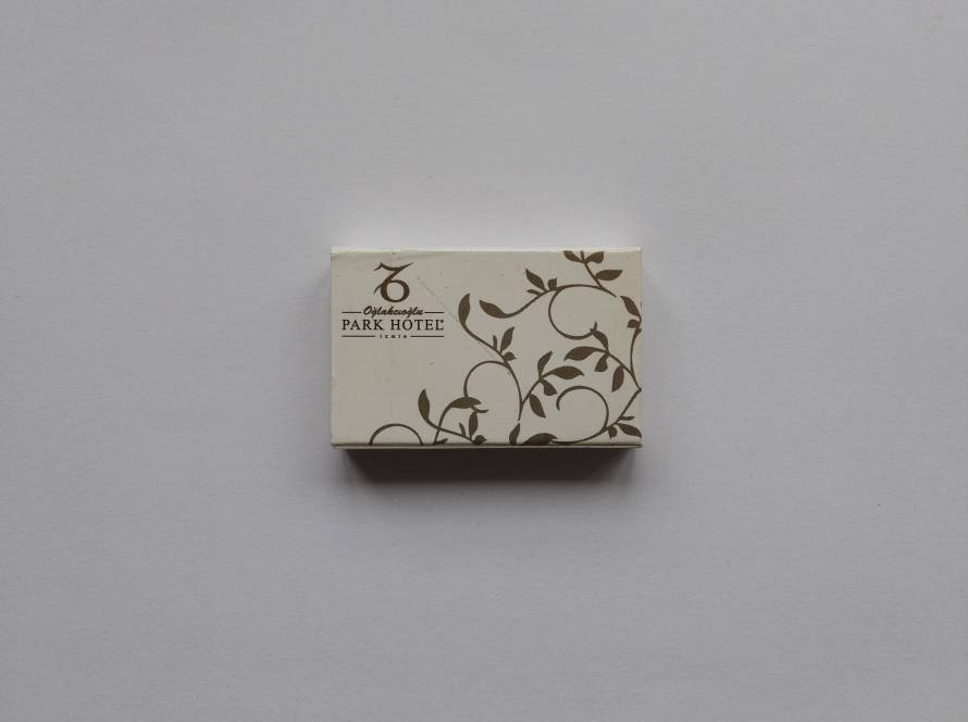 “Oğlakcıoğlu Park Hotel – İzmir” promotional matchbox. Elegant cream background with brown vine ornament pattern; refined hospitality branding.