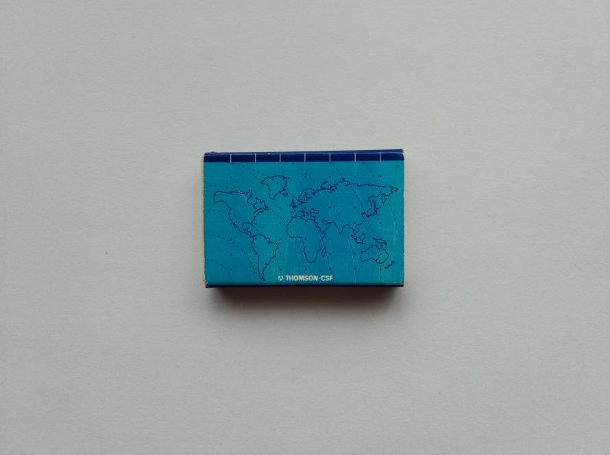 Corporate matchbox featuring a stylized world map and “THOMSON-CSF” branding. Clean blue cartographic design reflecting global technology and defense industry presence.