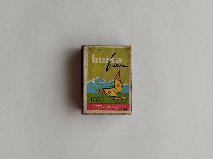 “Bursa Fuarı 1970” matchbox with stylized butterflies and mountain backdrop. Colorful tourism and fair promotion design (No. 70-12).
