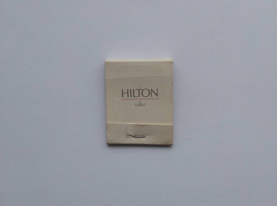Minimalist Hilton hotel matchbook with classic branding. Slight wear visible on striker area.