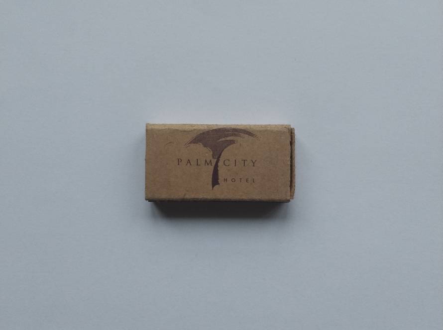 Palm City Hotel branded matchbook with minimalist palm logo design.