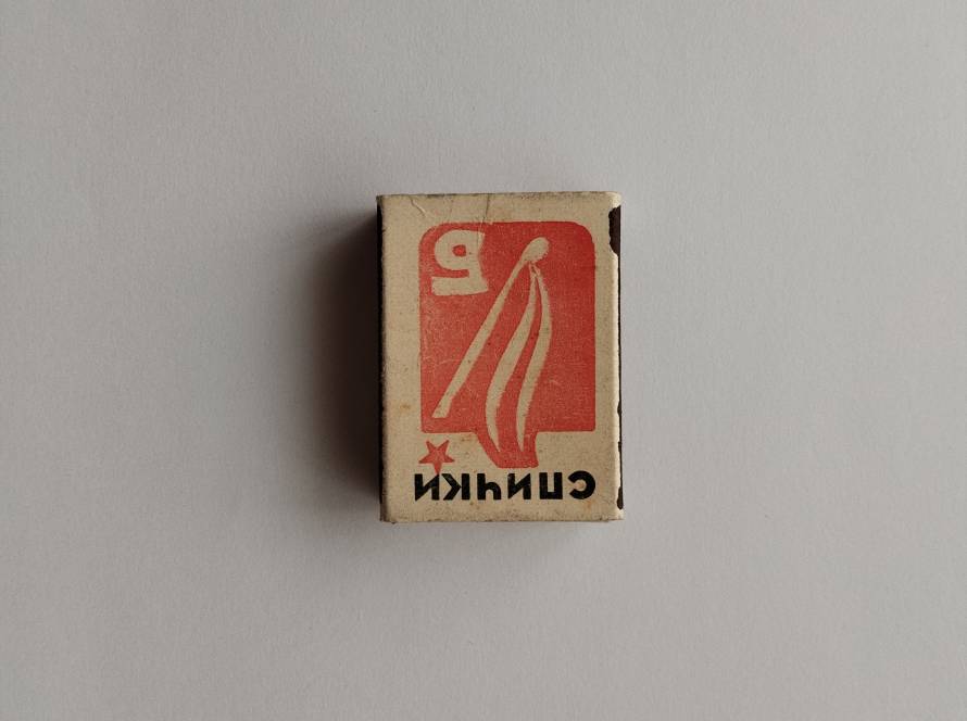 Bold red graphic with stylized flame and number “9,” simple Soviet-era design with worn edges.