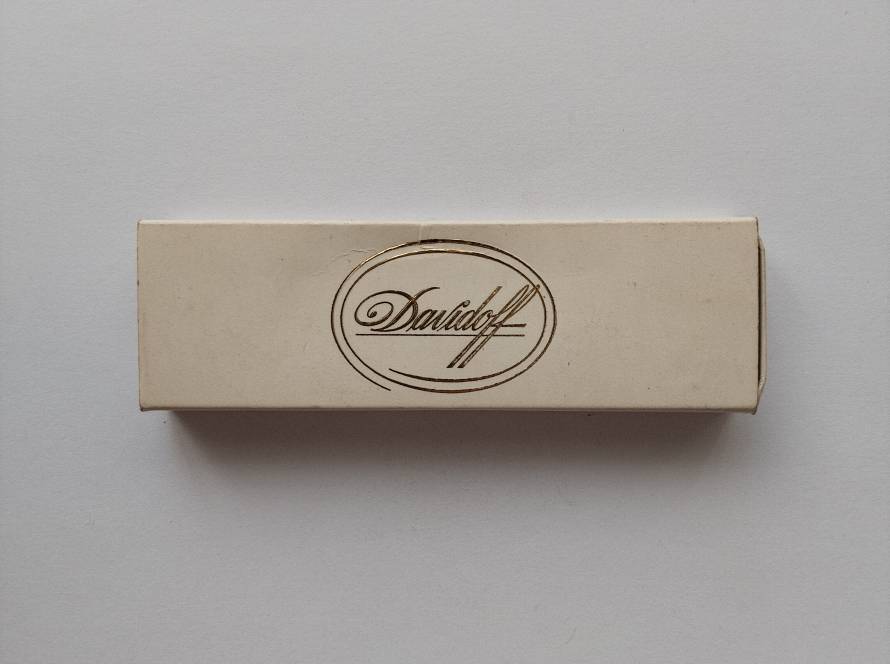 Elegant Davidoff cigar matchbox with gold logo and handwritten quote by Zino Davidoff on reverse.