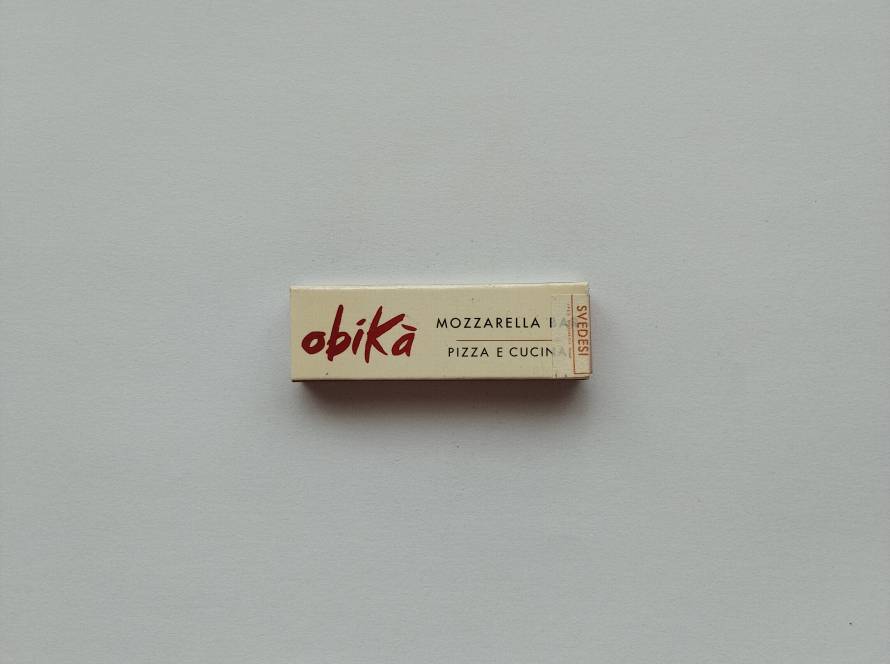 Obikà Mozzarella Bar branded matchbox with minimalist cream design and red logo; Italian restaurant advertising collectible with clean typography.