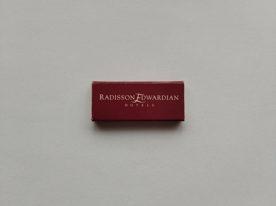 “Radisson Edwardian Hotels” promotional matchbox in deep burgundy design. Reverse lists hotel categories including Exclusive, De Luxe, and Traditional properties (e.g., The Savoy Court, The Berkshire).