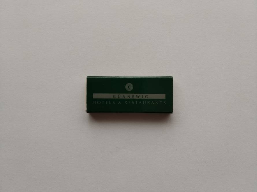 Günnewig Hotels & Restaurants matchbox in corporate green with silver logo bar; reverse includes website and branded concierge figure, characteristic of early 2000s German hotel chain marketing merchandise.