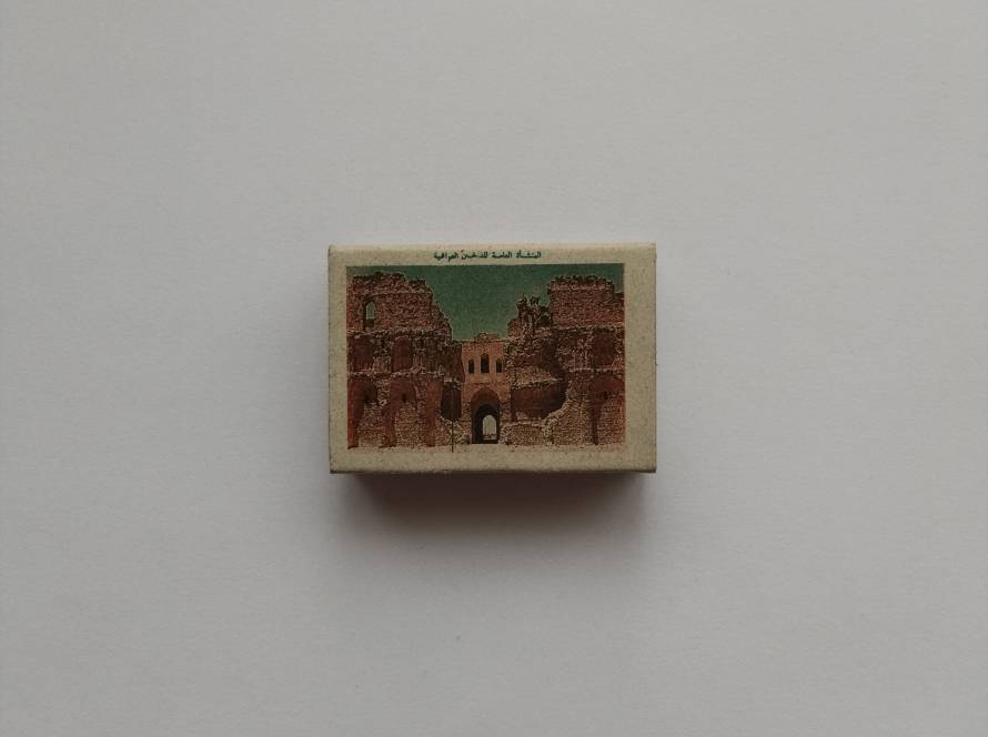 Matchbox issued by The Iraqi Tobacco State Enterprise with Arabic and English text. Likely produced as a government tobacco product accessory.