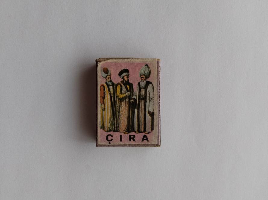 CIRA matchbox featuring three Ottoman figures in elaborate traditional attire, reflecting social hierarchy and clothing styles.