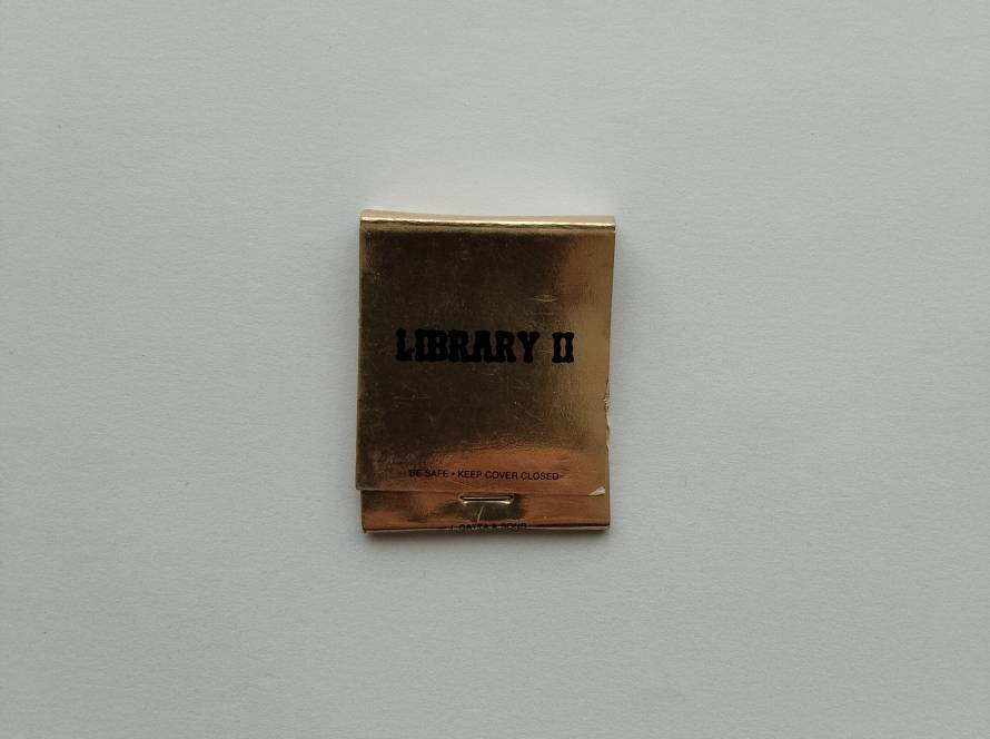 Metallic gold “Library II” matchbook with bold black typography and vintage styling.