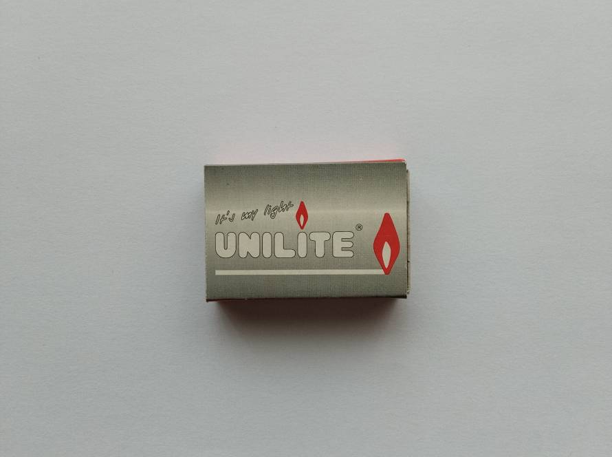 Modern Unilite matchbox with minimalist silver design and flame icon.