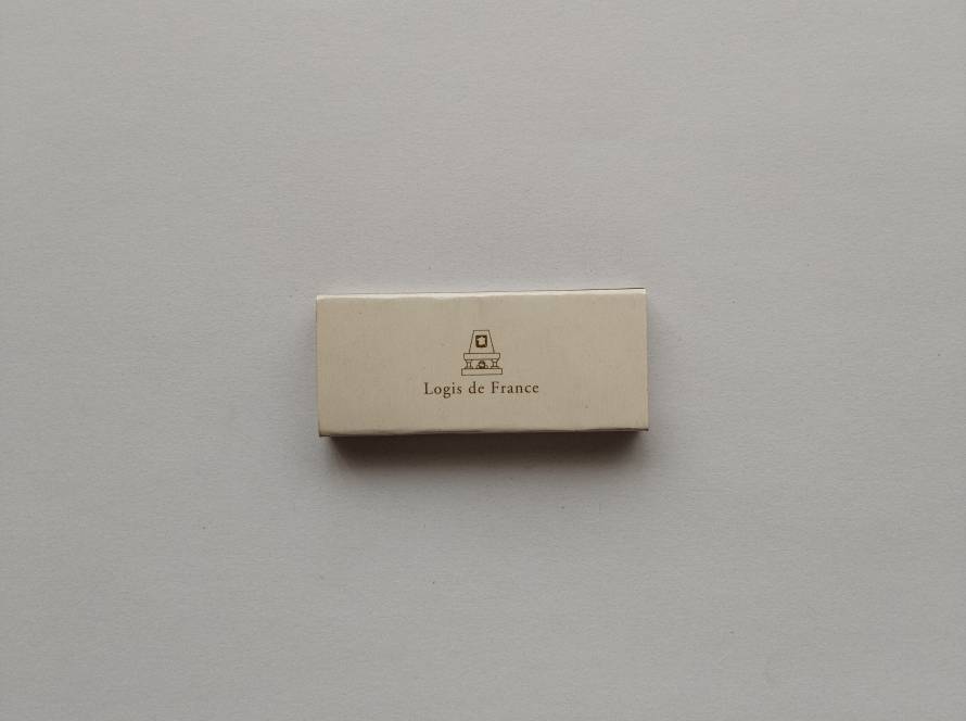Logis de France matchbox with minimalist design and detailed contact information on reverse, representing the French hotel network.