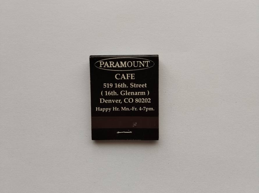 Paramount Café matchbox from Denver, Colorado, with detailed address and contact info, including happy hour promotion—classic local restaurant advertising piece.