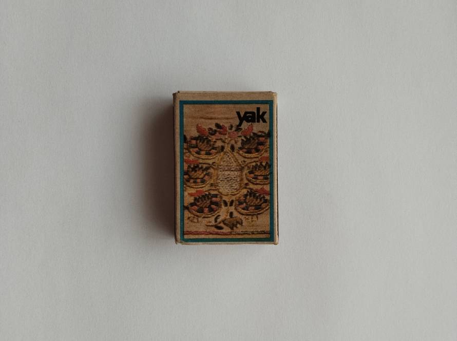 Decorative Ottoman-style motif with intricate symmetrical patterns; Yak branded.
