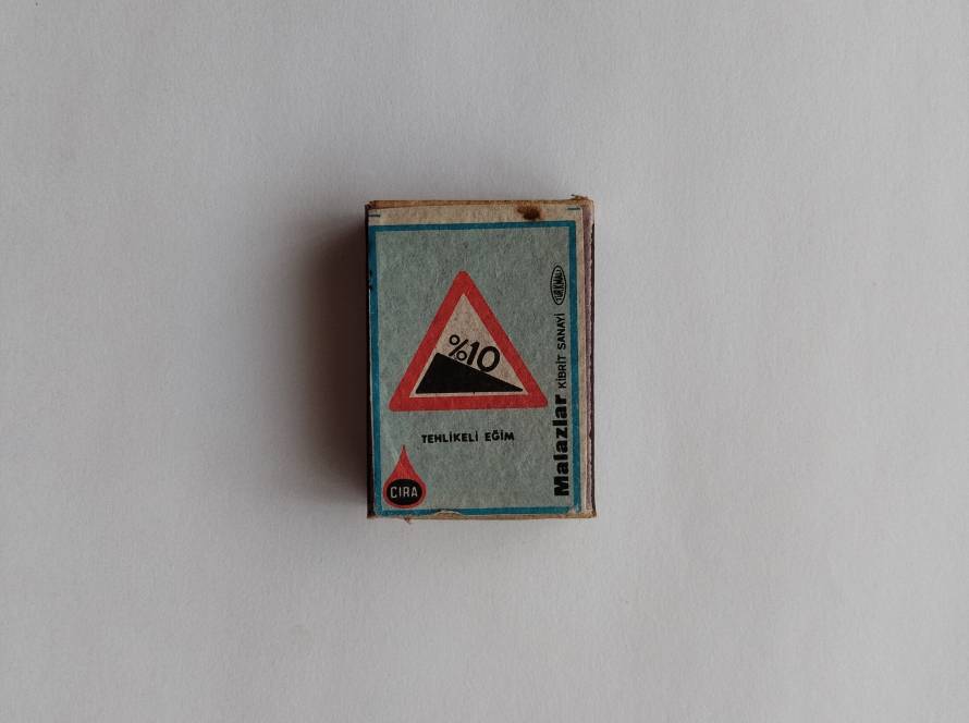 Vintage warning label indicating a dangerous slope, illustrated with a steep incline graphic.