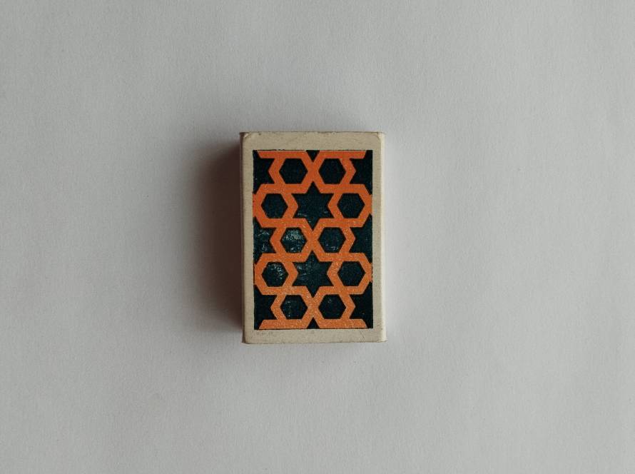 Abstract geometric pattern with repeating star and hexagonal shapes in orange and black.