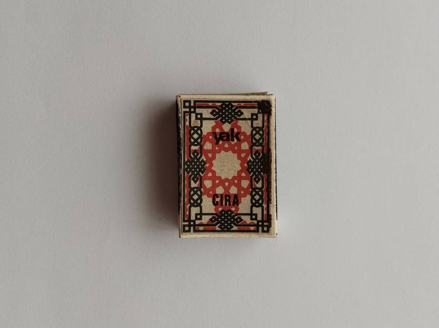 Yak Çıra branded Turkish matchbox featuring red-black symmetrical folk-art inspired geometric motif; reverse carries TEKEL tax marking with 1986 print.