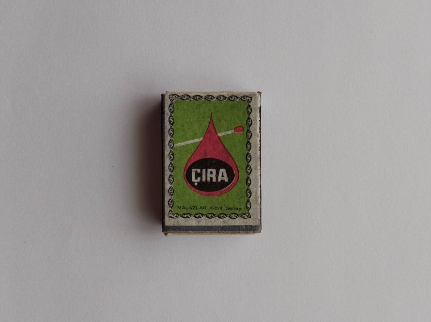 Vintage CIRA Malazlar Kibrit Sanayi matchbox with green background and red flame-drop logo design crossed by a matchstick illustration.