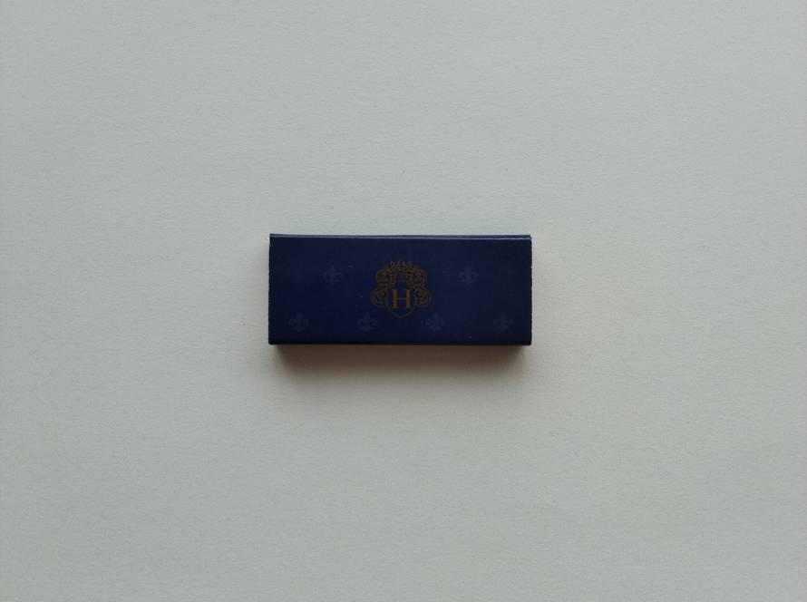 Elegant promotional matchbox featuring a decorative hotel monogram design. A hospitality advertising collectible with premium presentation.