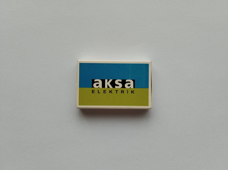 Aksa Elektrik corporate promotional matchbox displaying company logo and brand colors.