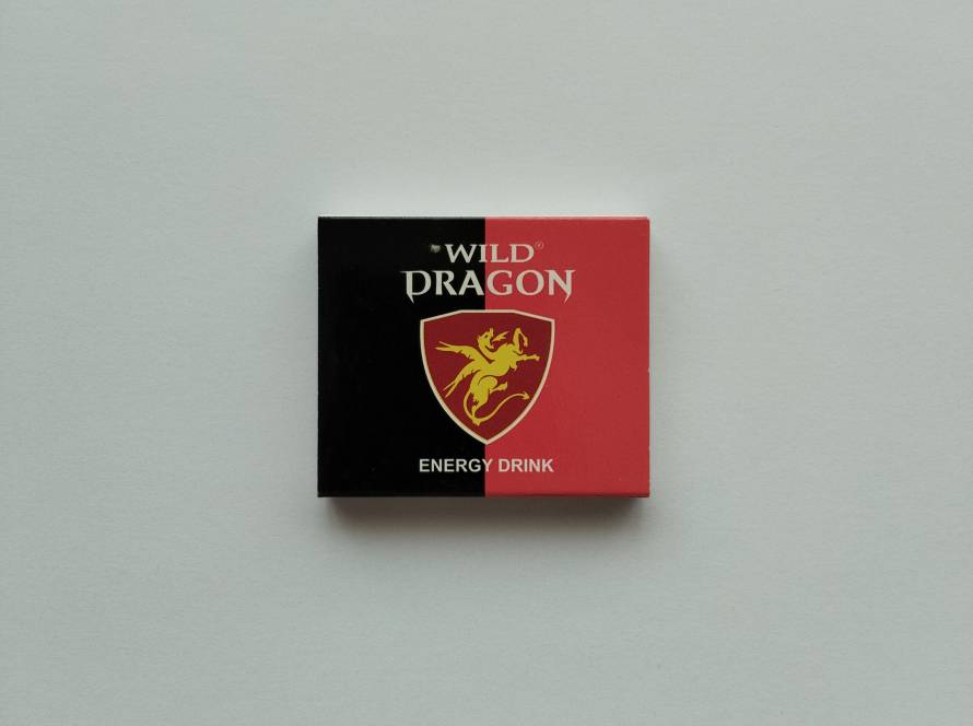 Wild Dragon Energy Drink promotional matchbox featuring red-black design and dragon shield logo.