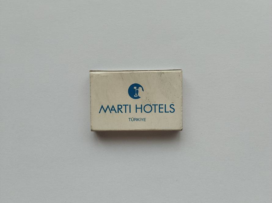 Vintage Martı Hotels promotional matchbox featuring the iconic Martı Hotels logo and contact information for Martı Holiday Village, Martı La Perla and Martı Myra properties in Marmaris and Kemer. A collectible hospitality advertising matchbox from Turkey’s tourism sector.