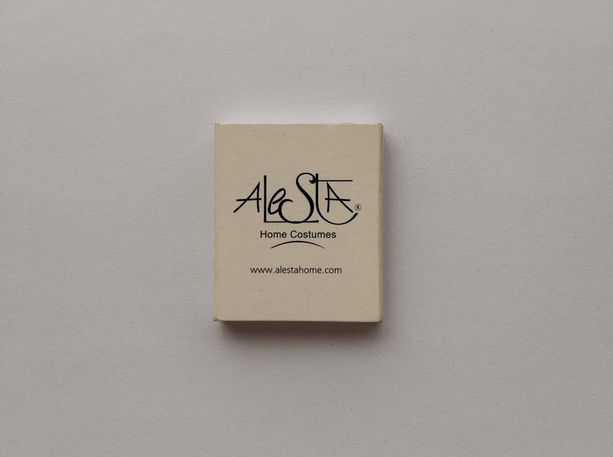 Alesta Home Costumes promotional matchbox featuring company branding and website address. A retail marketing collectible.