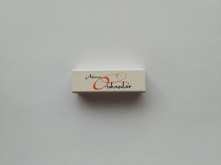 Promotional matchbox for Adana Onbaşılar Restaurant in Ankara, featuring restaurant branding and contact information for its Çayyolu branch.