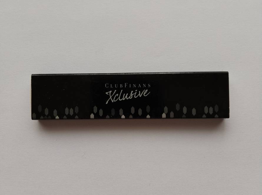 Promotional matchbox for ClubFinans Xclusive, featuring a sleek black design with ClubFinans branding, website, and SMS membership information. A modern corporate advertising piece in excellent condition.