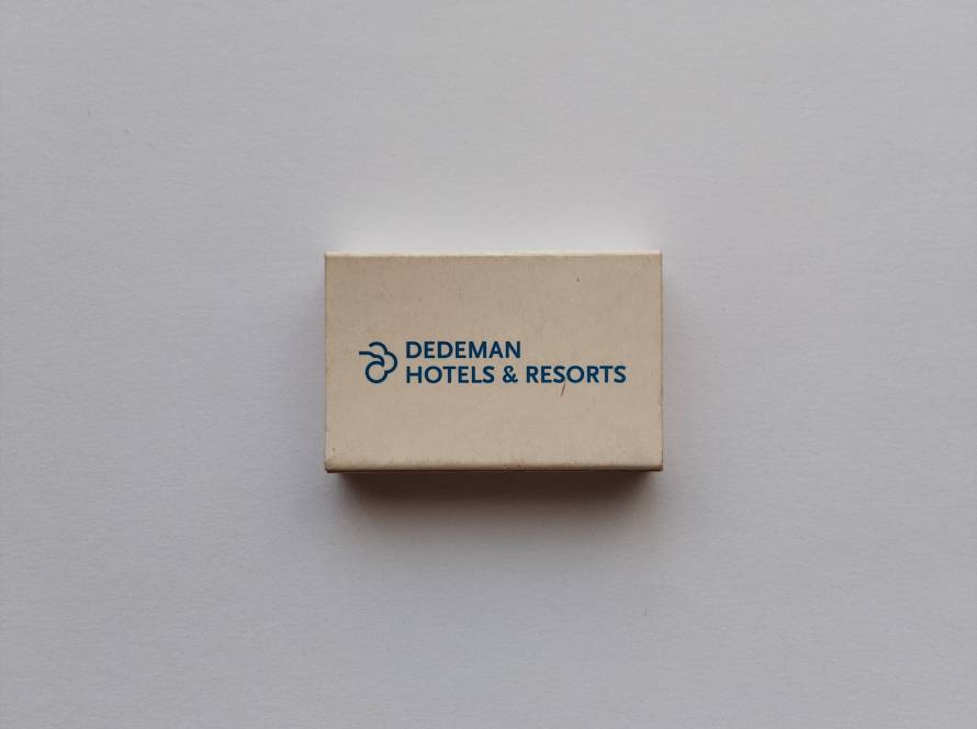 Promotional matchbox for Dedeman Hotels & Resorts featuring the iconic Dedeman logo in blue on a clean white background.