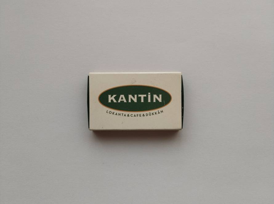 Promotional matchbox for Kantin Lokanta • Cafe • Dükkan. Features a green oval logo on a cream background with business contact information.
