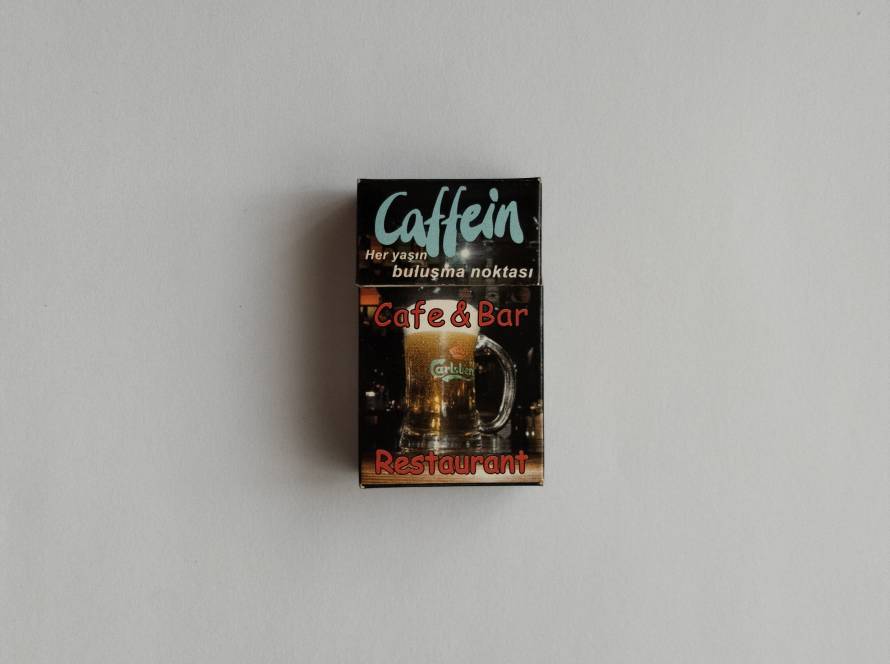 Promotional matchbox for Caffein Cafe & Bar Restaurant. Features a beer glass design with modern café branding. Restaurant advertising collectible.