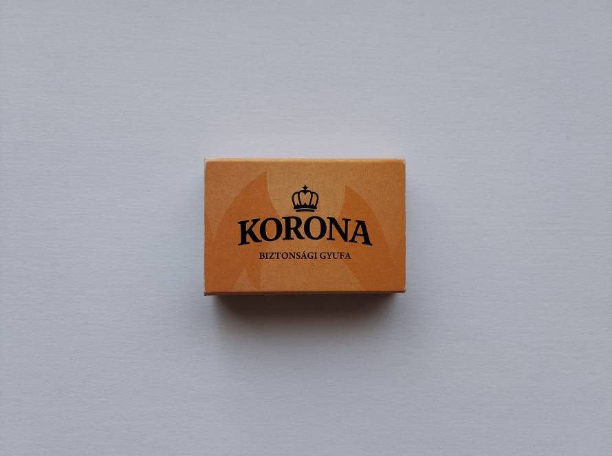 Korona "Biztonsági Gyufa" (Safety Matches) matchbox produced for the Hungarian market. Features the Korona crown logo on the front and multilingual manufacturer, safety, and hazard information on the reverse.